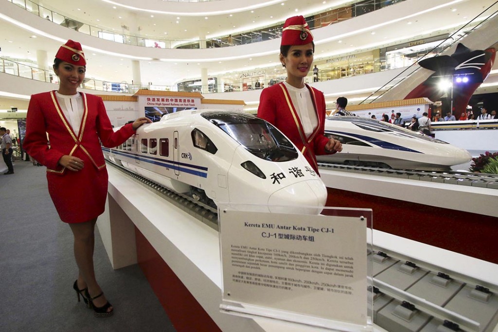 Attendants pose for a photo beside the models of a high speed train during the China High Speed Railway on Fast Track exhibition in Jakarta, Indonesia, August 13, 2015 in this file photo taken by Antara Foto.   Indonesia is expected to decide on its key Jakarta-Bandung rail project this week.  REUTERS/Rivan Awal Lingga/Antara Foto/FilesATTENTION EDITORS - THIS IMAGE HAS BEEN SUPPLIED BY A THIRD PARTY. IT IS DISTRIBUTED, EXACTLY AS RECEIVED BY REUTERS, AS A SERVICE TO CLIENTS. FOR EDITORIAL USE ONLY. NOT FOR SALE FOR MARKETING OR ADVERTISING CAMPAIGNS MANDATORY CREDIT. INDONESIA OUT. NO COMMERCIAL OR EDITORIAL SALES IN INDONESIA  GLOBAL BUSINESS WEEK AHEAD PACKAGE - SEARCH "BUSINESS WEEK AHEAD SEPTEMBER 28" FOR ALL 24 IMAGES
