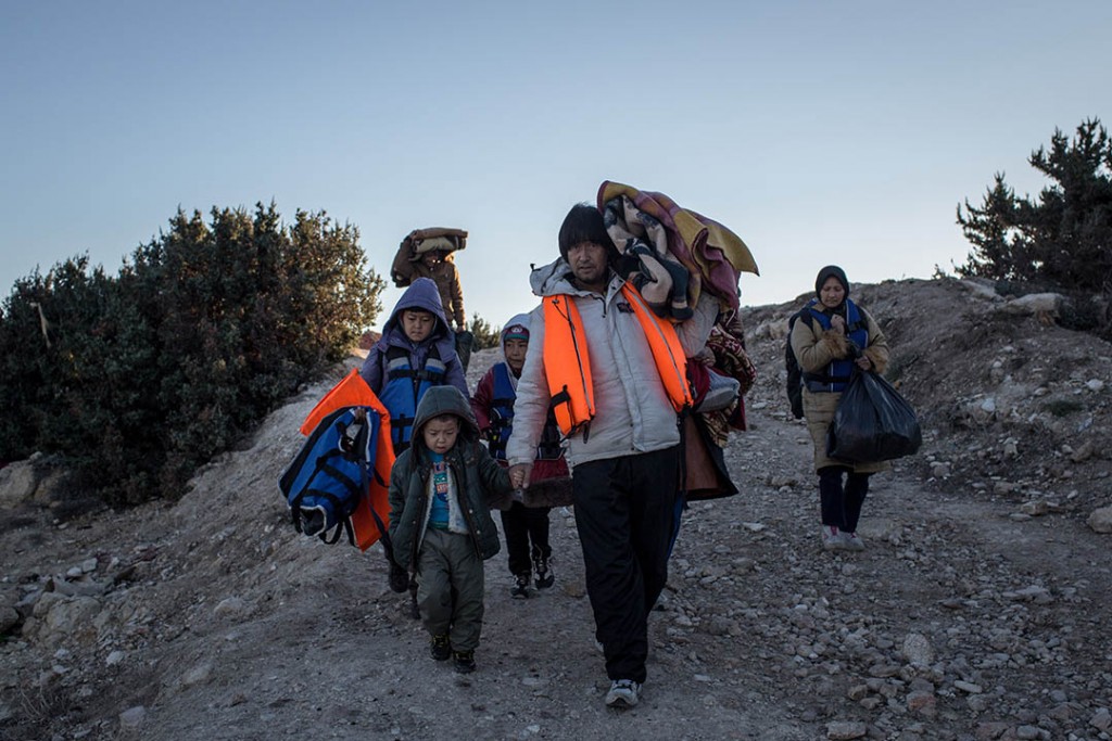 CESME, TURKEY - DECEMBER 04: An Afghan refugee family walk with their belongings and lifejackets to a campsite to wait for a boat to leave Turkey at a launching point in the coastal town of Cesme on December 4, 2015 in Cesme, Turkey. The flow of boats from Turkey has slowed after a 3bn euro deal was struck between the EU and Turkey, to slow the flow of migrants and refugees to Europe. Since the deal was struck on November 29th, Turkish police have rounded up approximately 1300 migrants and arrested a number of smugglers. The winter weather and increased police checkpoints on the roads leading to launch points have slowed the amount of boats leaving turkish shores. (Photo by Chris McGrath/Getty Images)