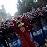 A protester shouts in front of police during a rally against overhaul of the military and civil service pension funds in Taichung